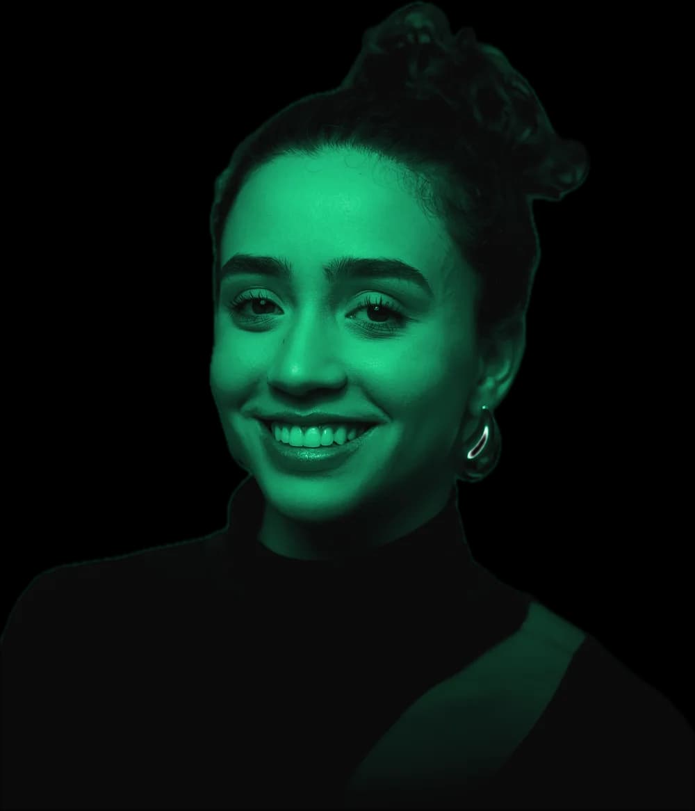 Camila Delgado sorrindo, de blusa preta de gola alta